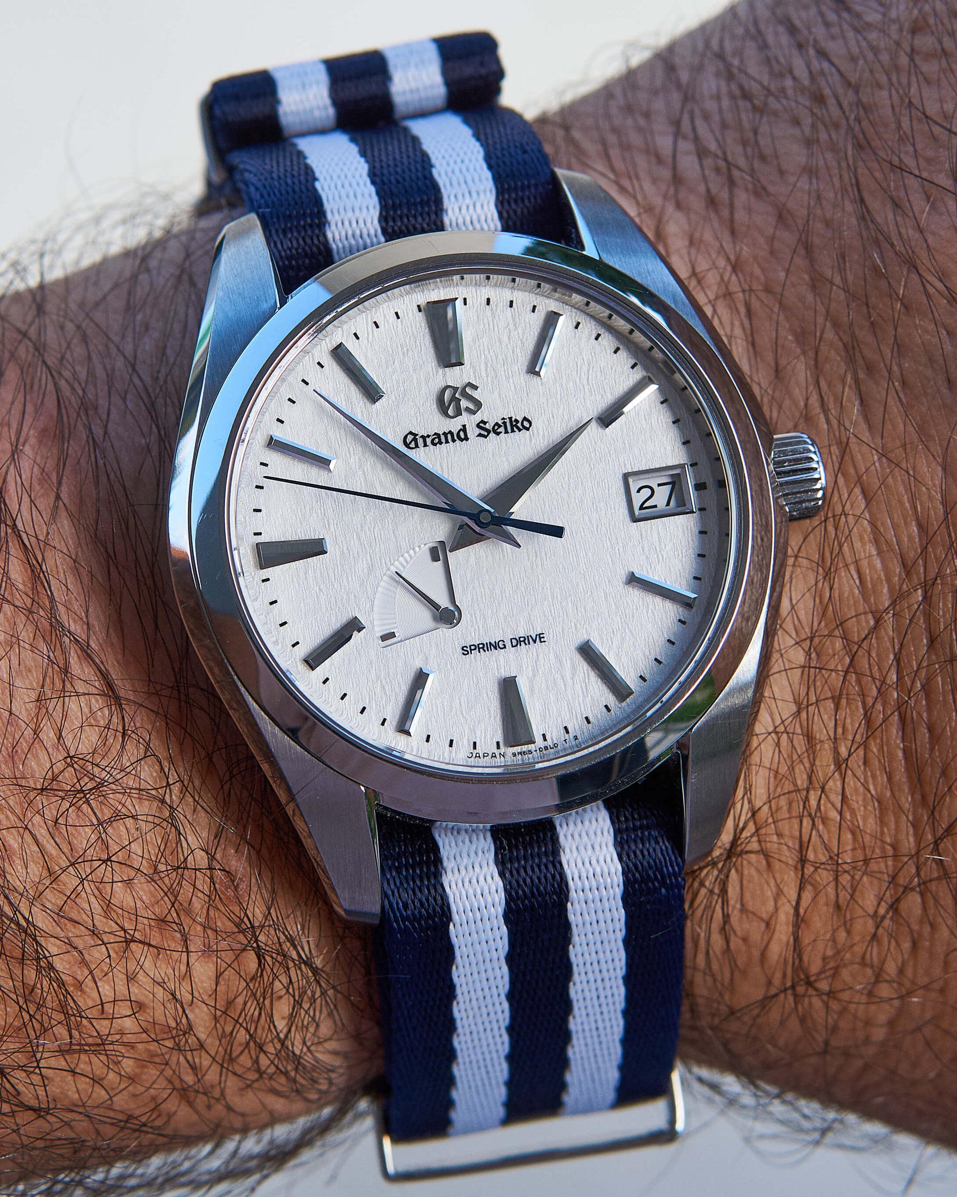 Grand Seiko Snowflake with navy blue and white striped premium nylon strap on wrist
