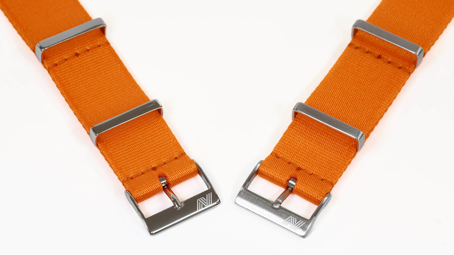 Two orange watch straps with stailnless steel buckles on a white background